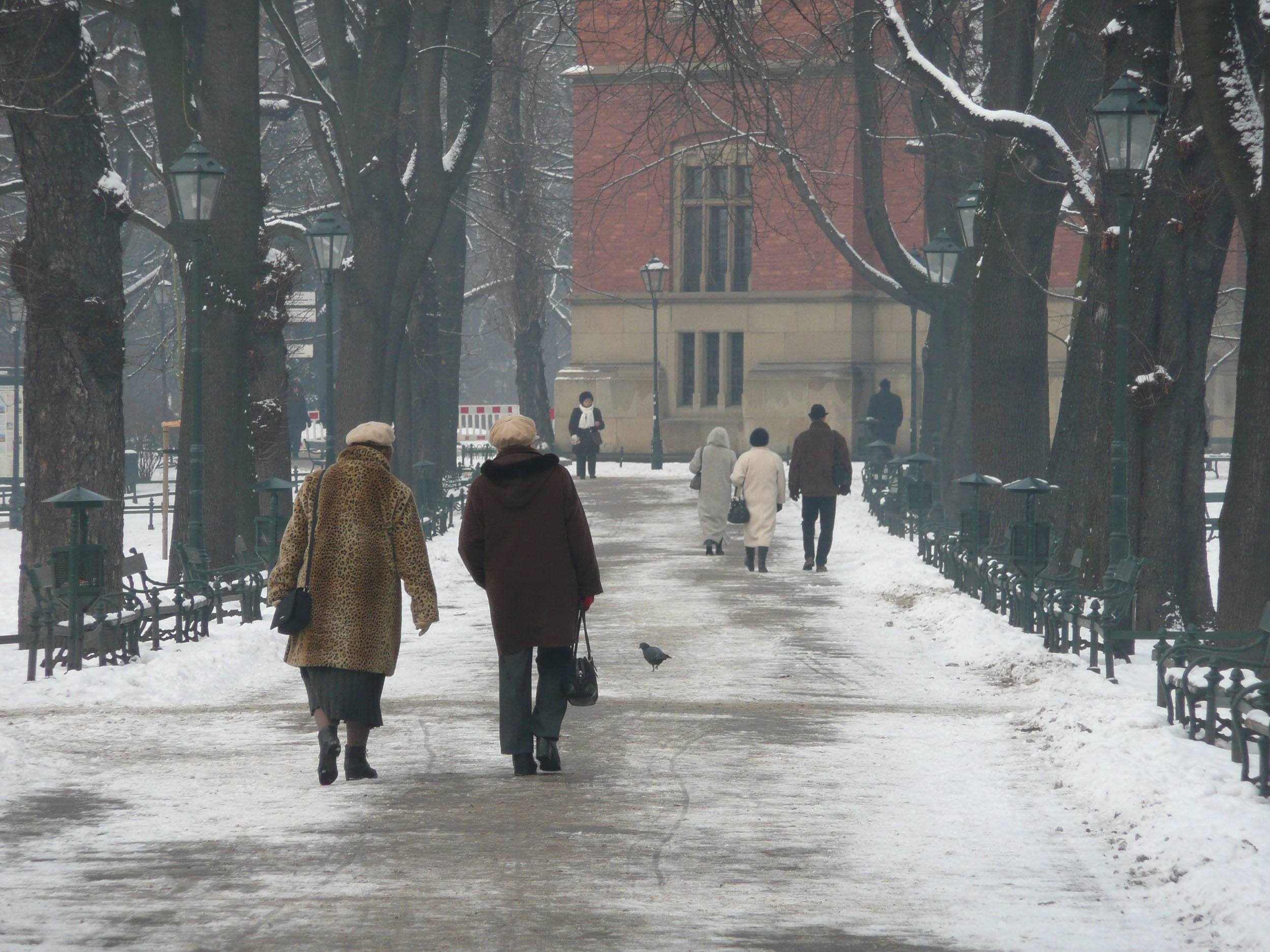 Women in fur coats walking through a park in Krakow Poland