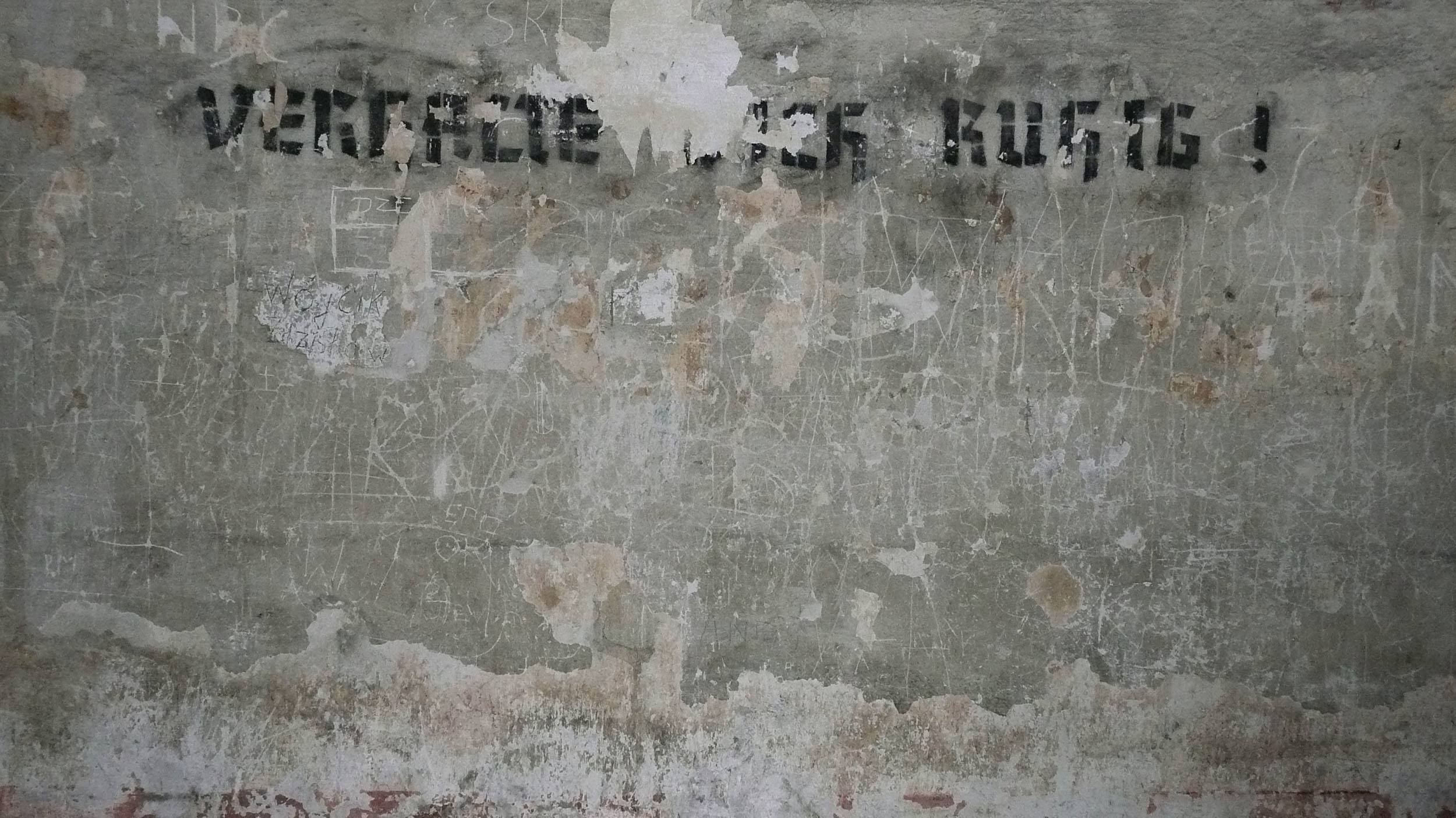 Writing on a concrete wall inside Birkenau concentration camp in Poland