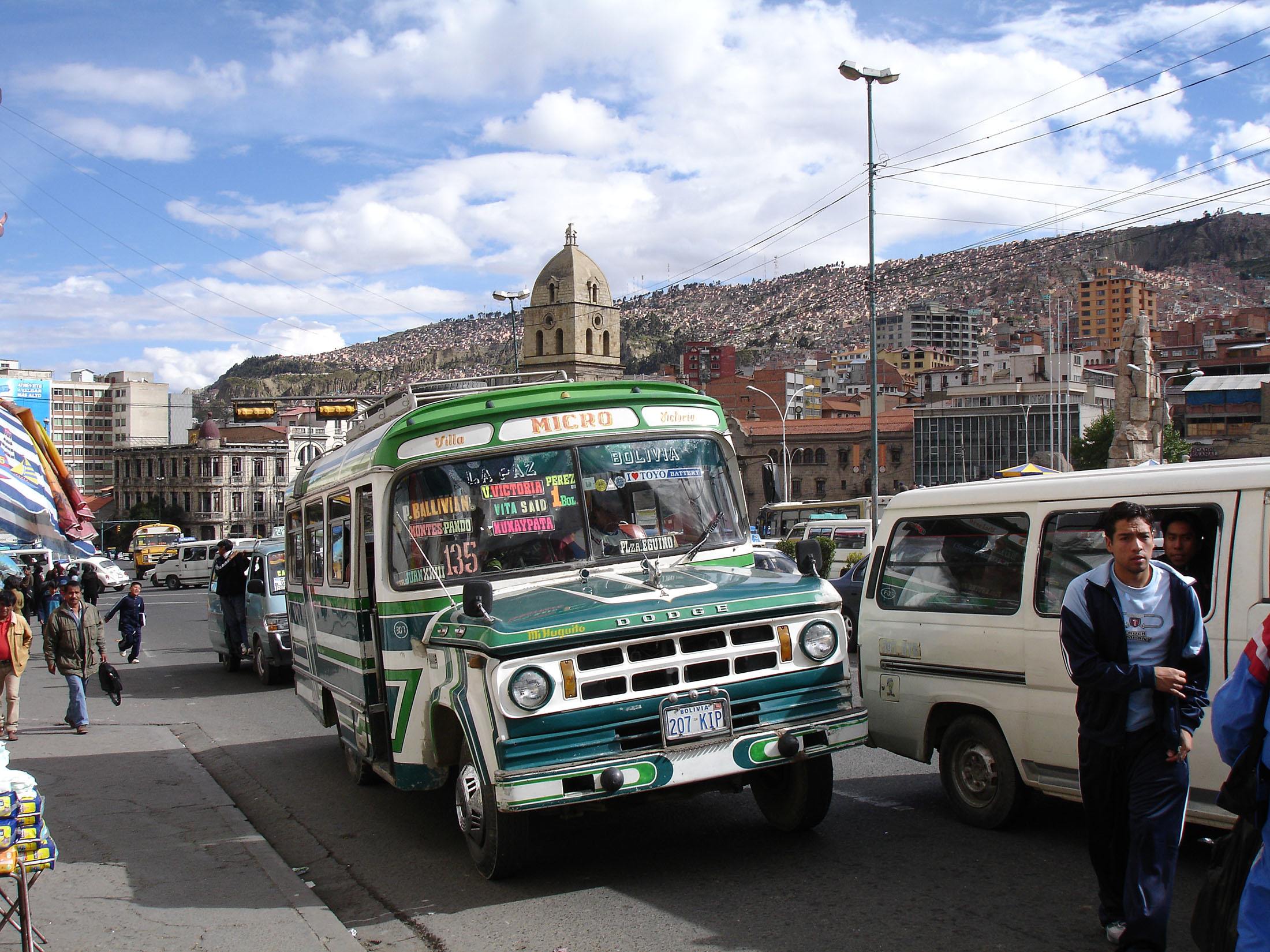 A green city bus moving through La Paz Bolivia