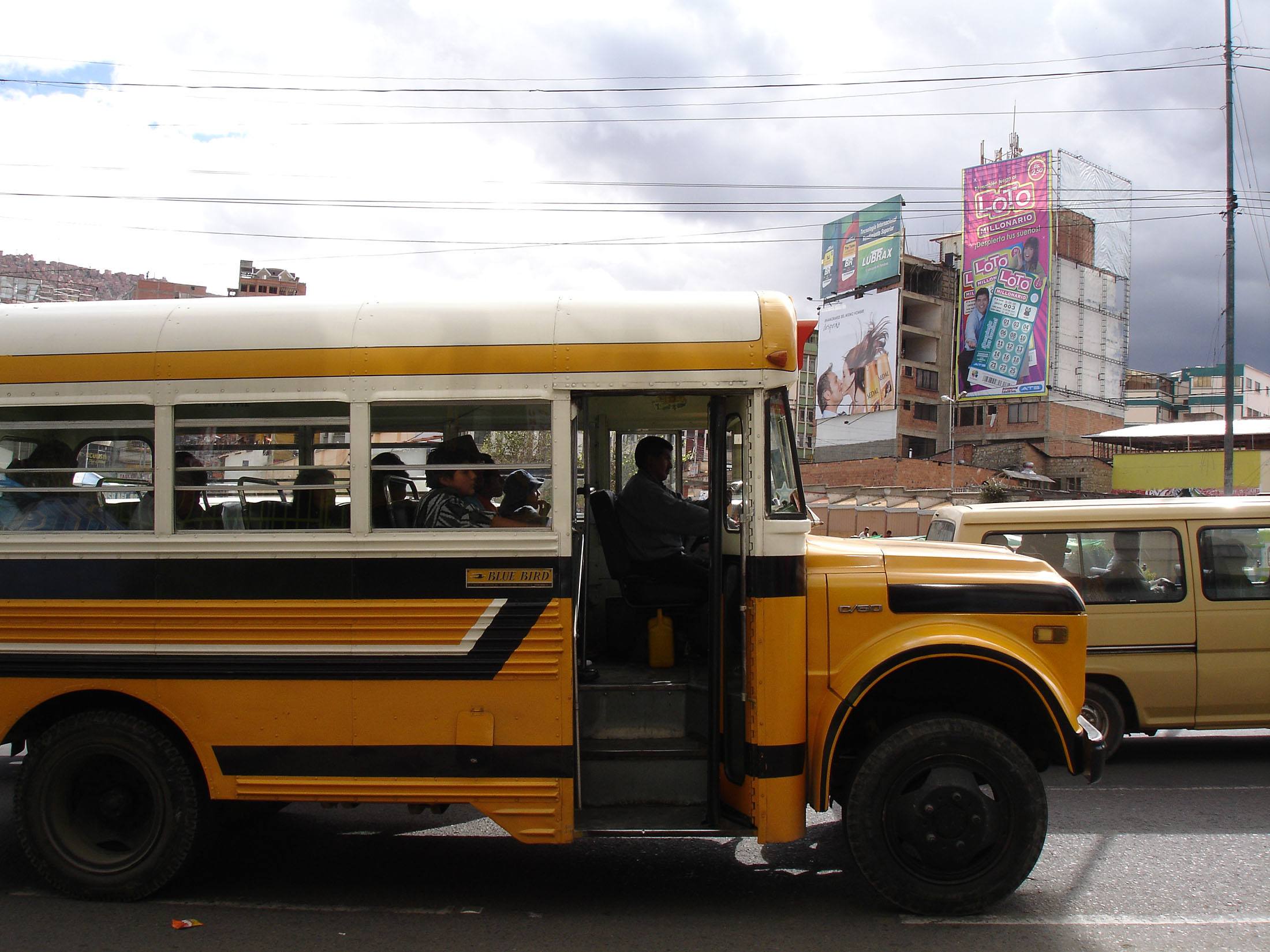 A yellow city bus moving through La Paz Bolivia