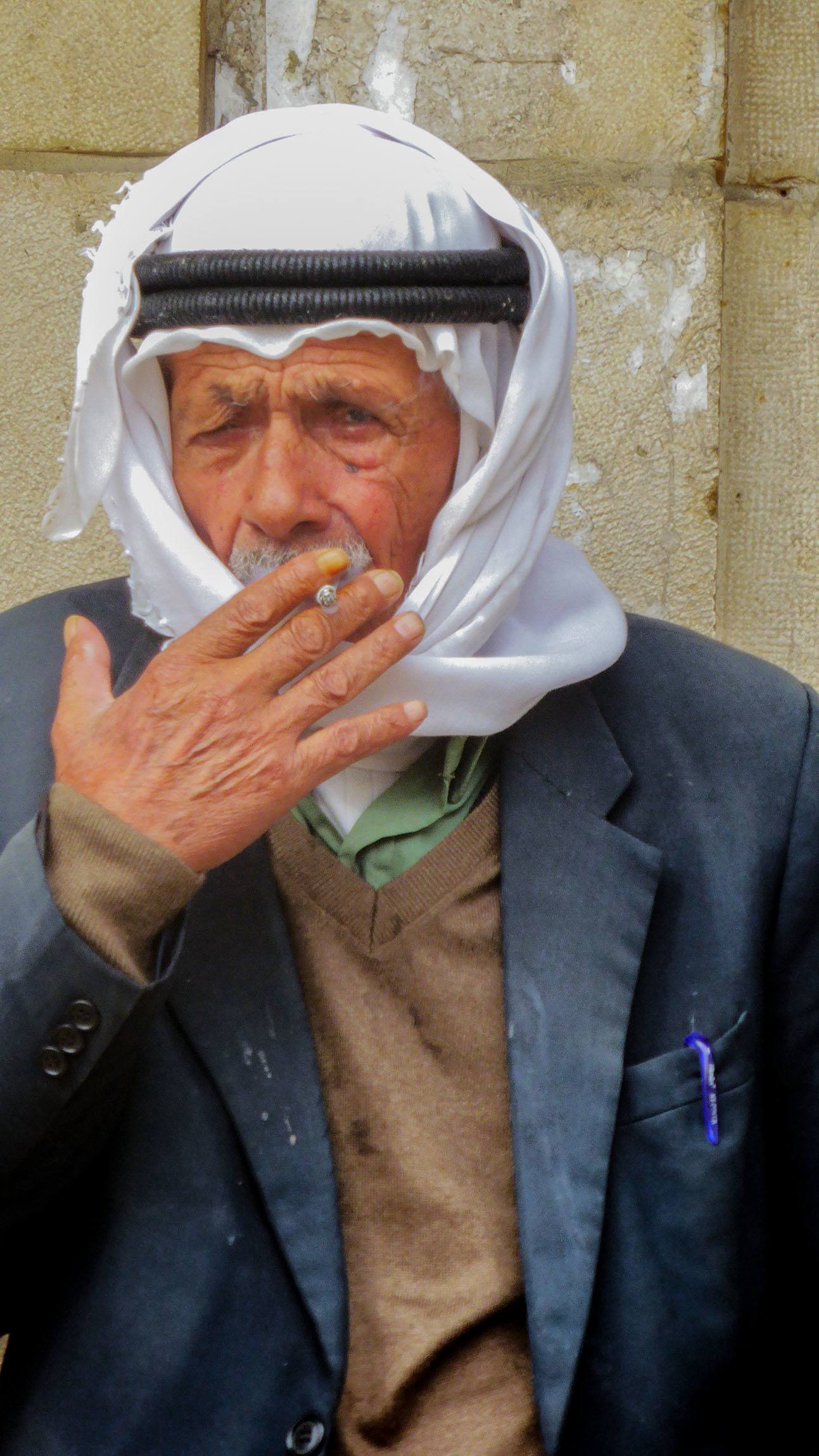 Elderly man smoking cigarette in streets of Nablus Palestine