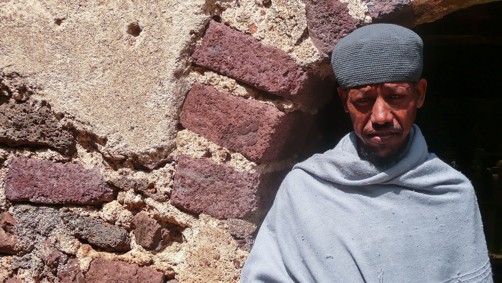 A monk standing in a doorway of Kebran Gabriel Monastery Lake Tana Ethiopia