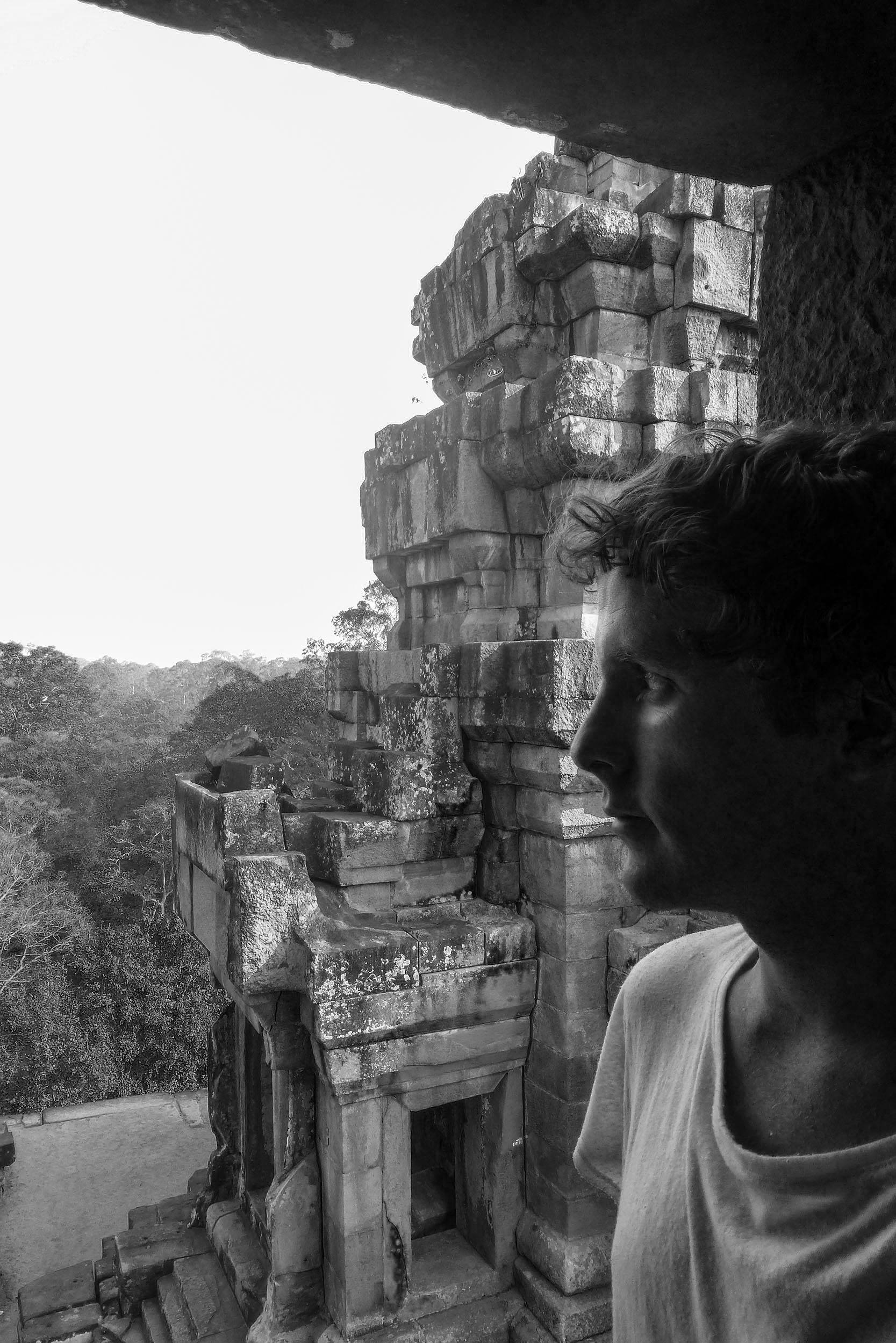 Ben looking out of a window inside Angkor Wat Cambodia