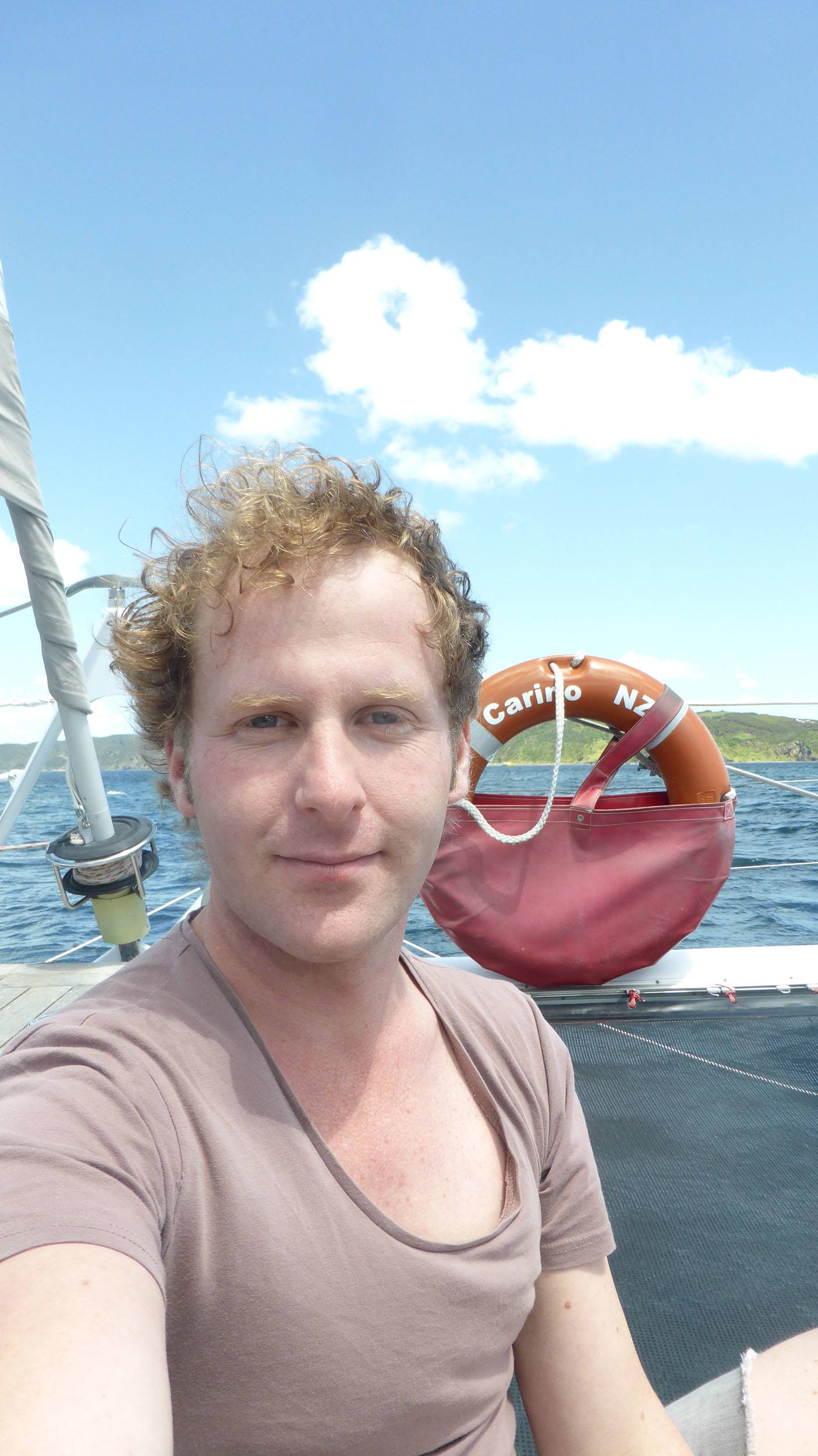 Ben on catamaran sailing through Bay of Islands North Island New Zealand