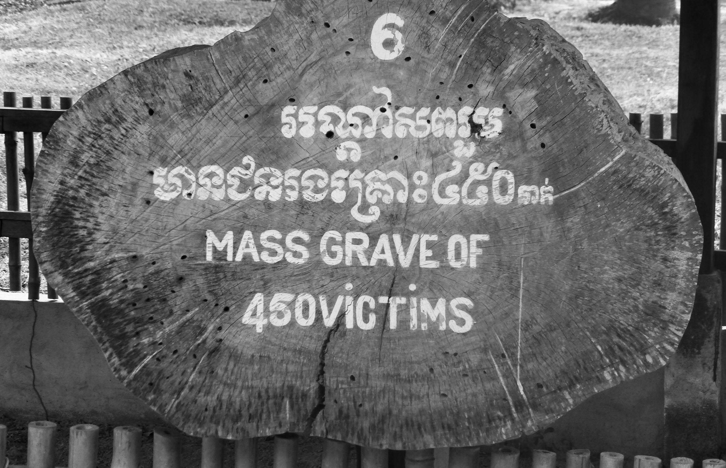 Sign indicating a mass grave at the Killing Fields Phnom Penh Cambodia.