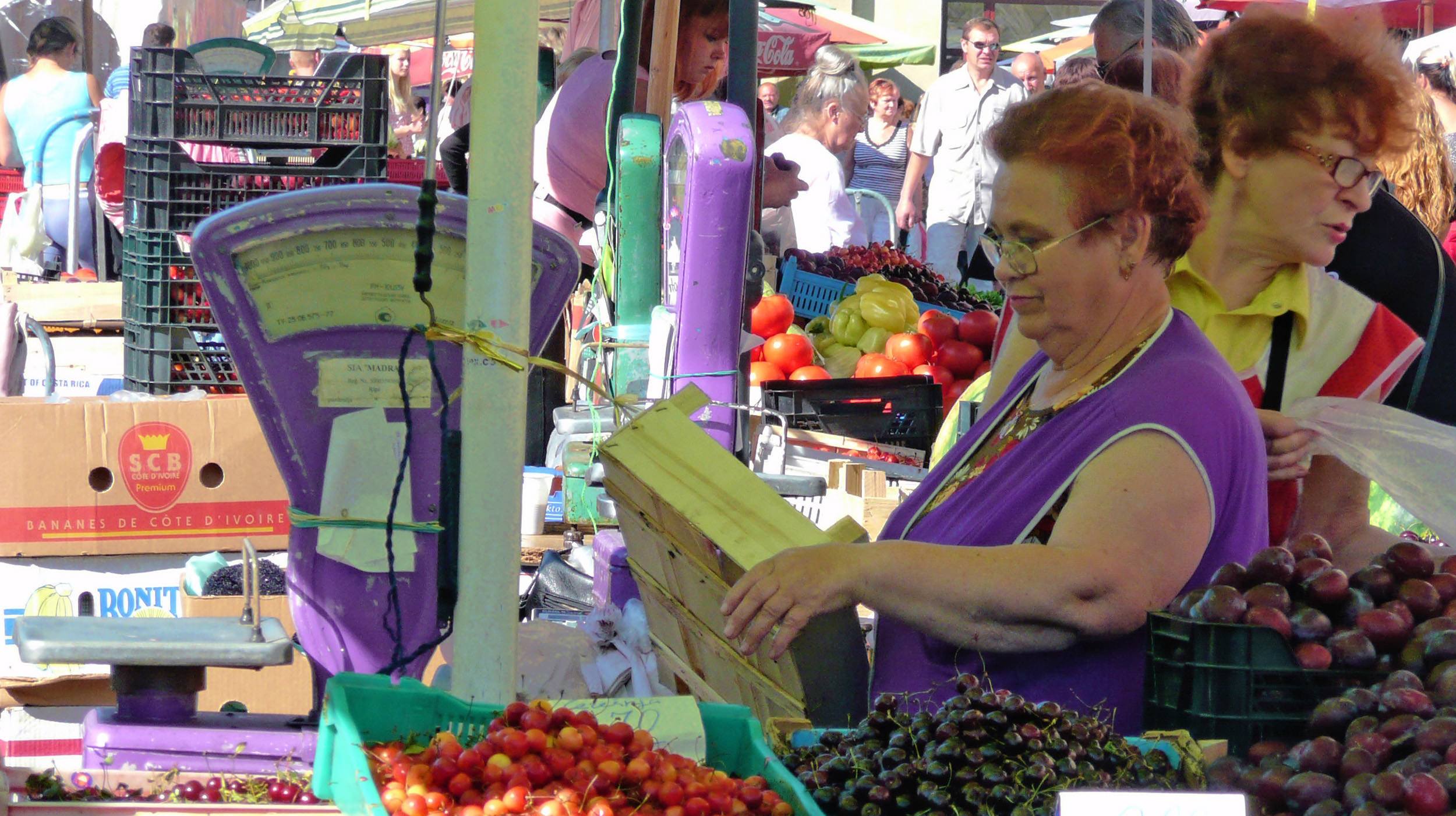 Woman selling berries at a market in Riga Latvia