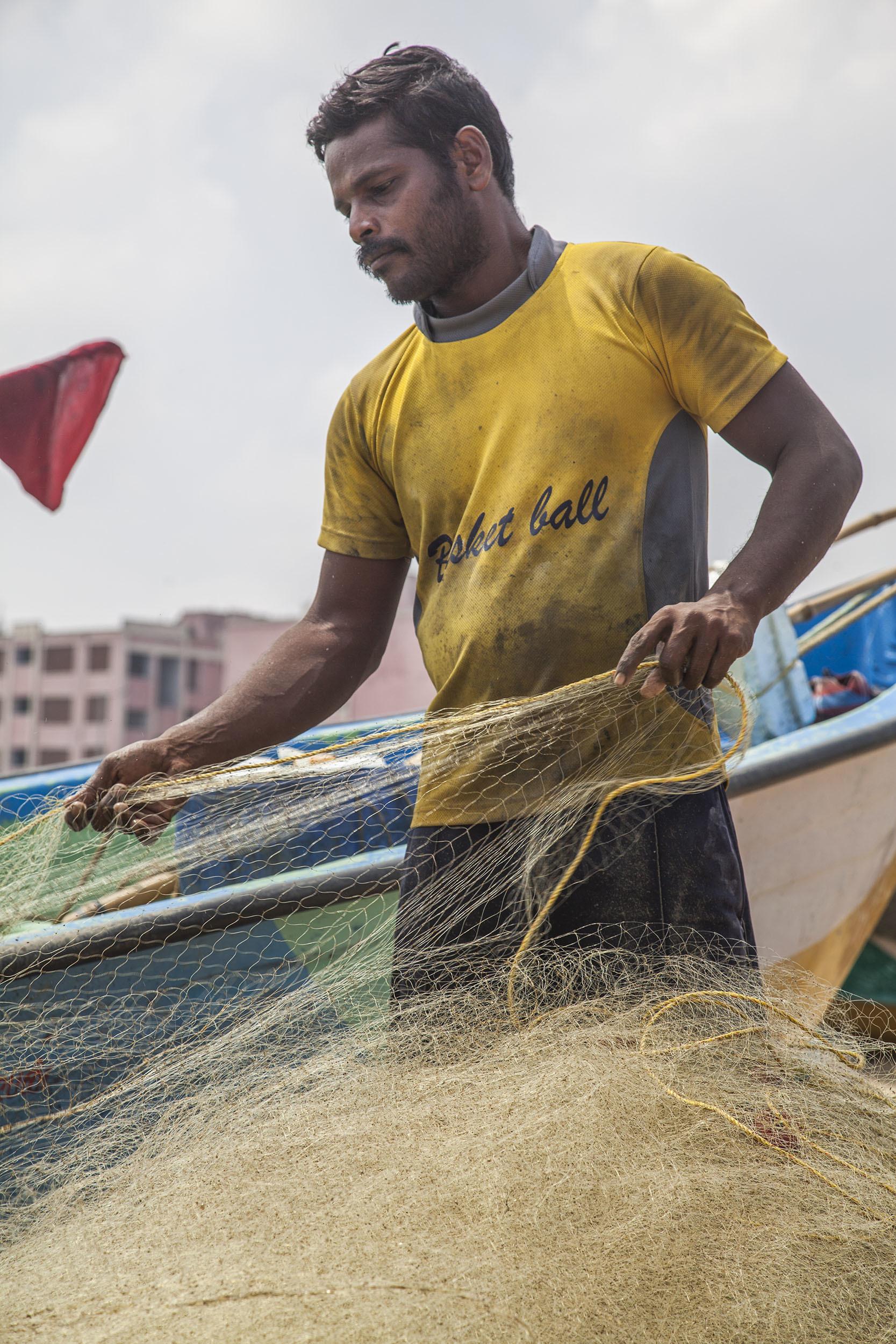 A fisherman preparing nets on the beach in Chennai India