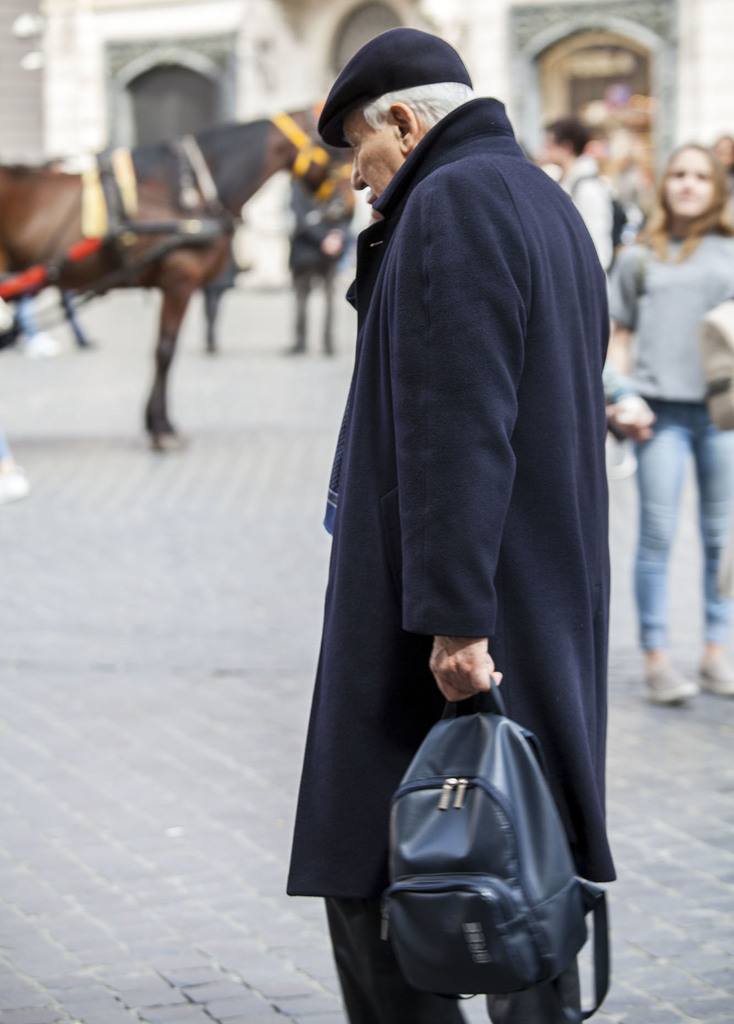 A well-dressed Italian man walking through Piazza di Spagna in Rome Italy