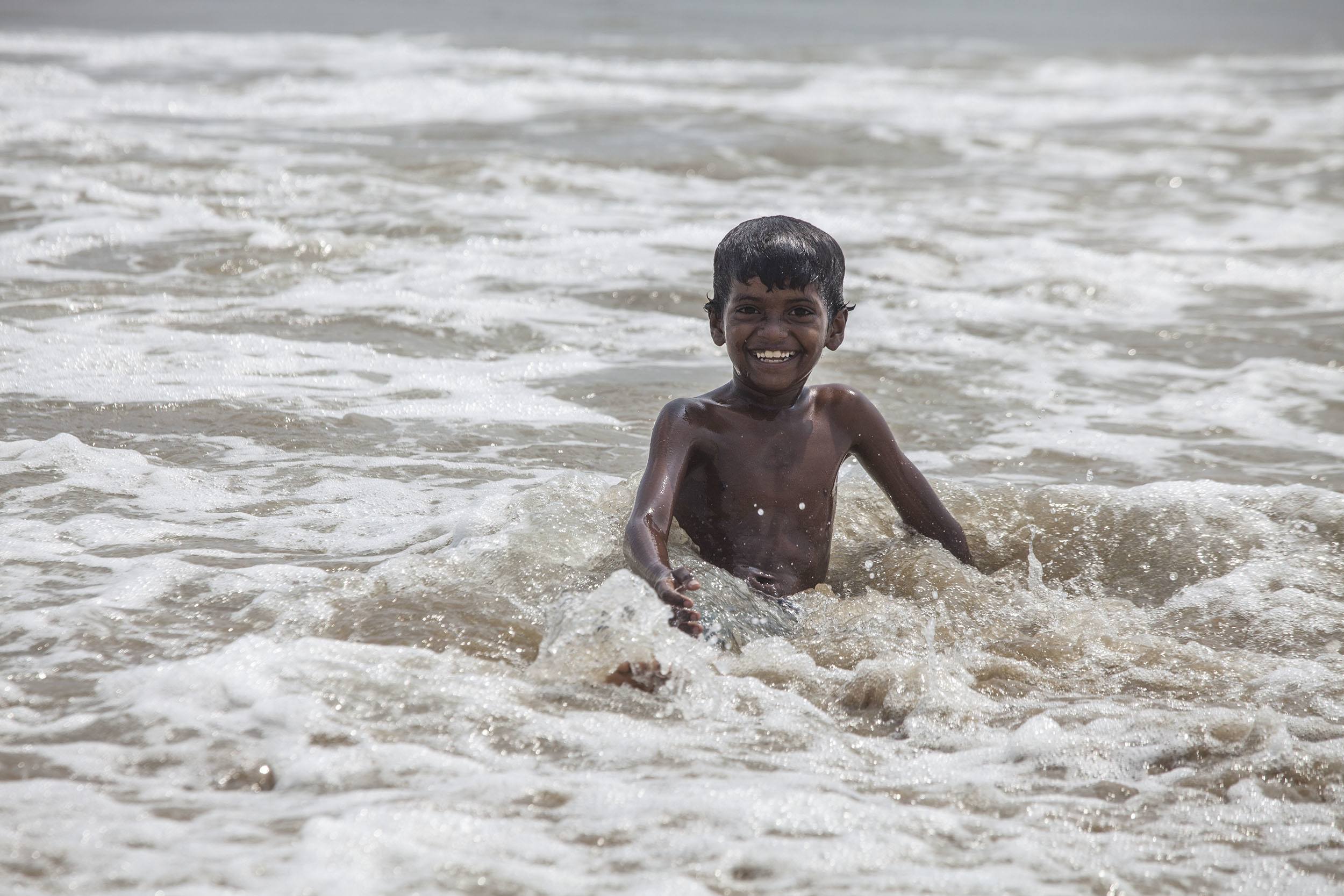 A young Indian boy swimming in the ocean in Chennai India