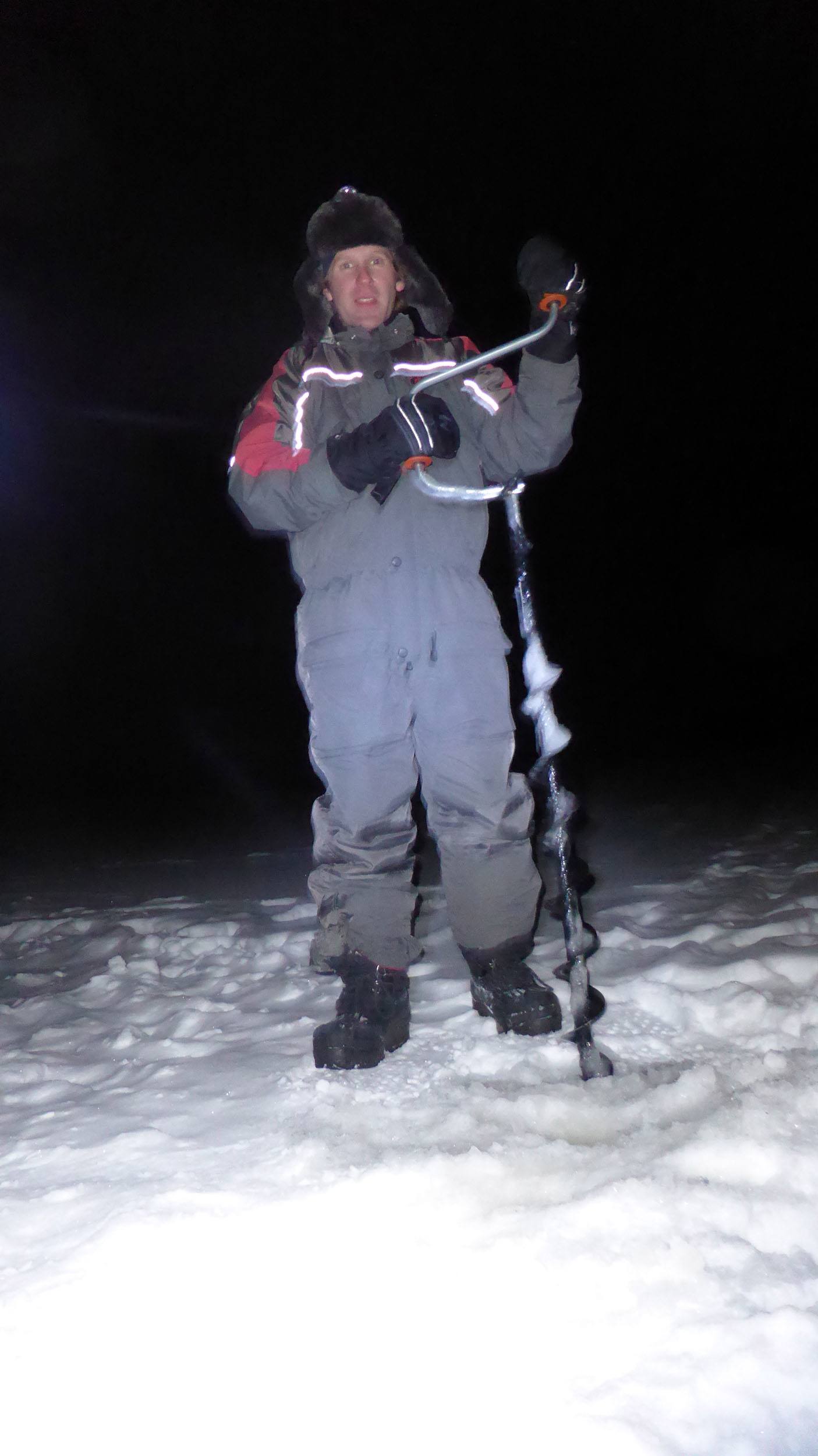Ben with a drill on a frozen lake at Camp Alta Sweden