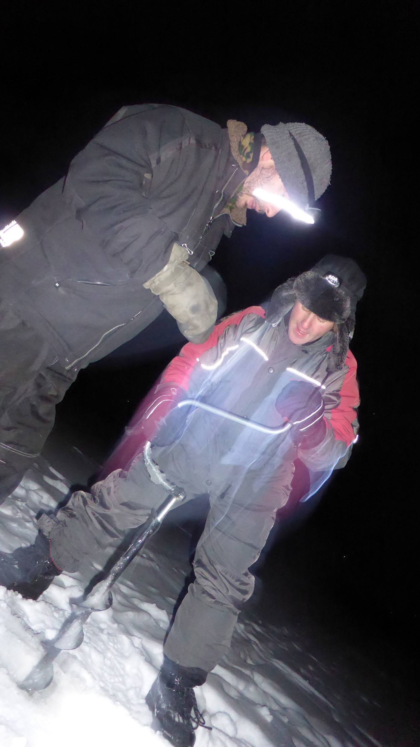 Camp Alta host instructing Ben how to drill through the ice Sweden