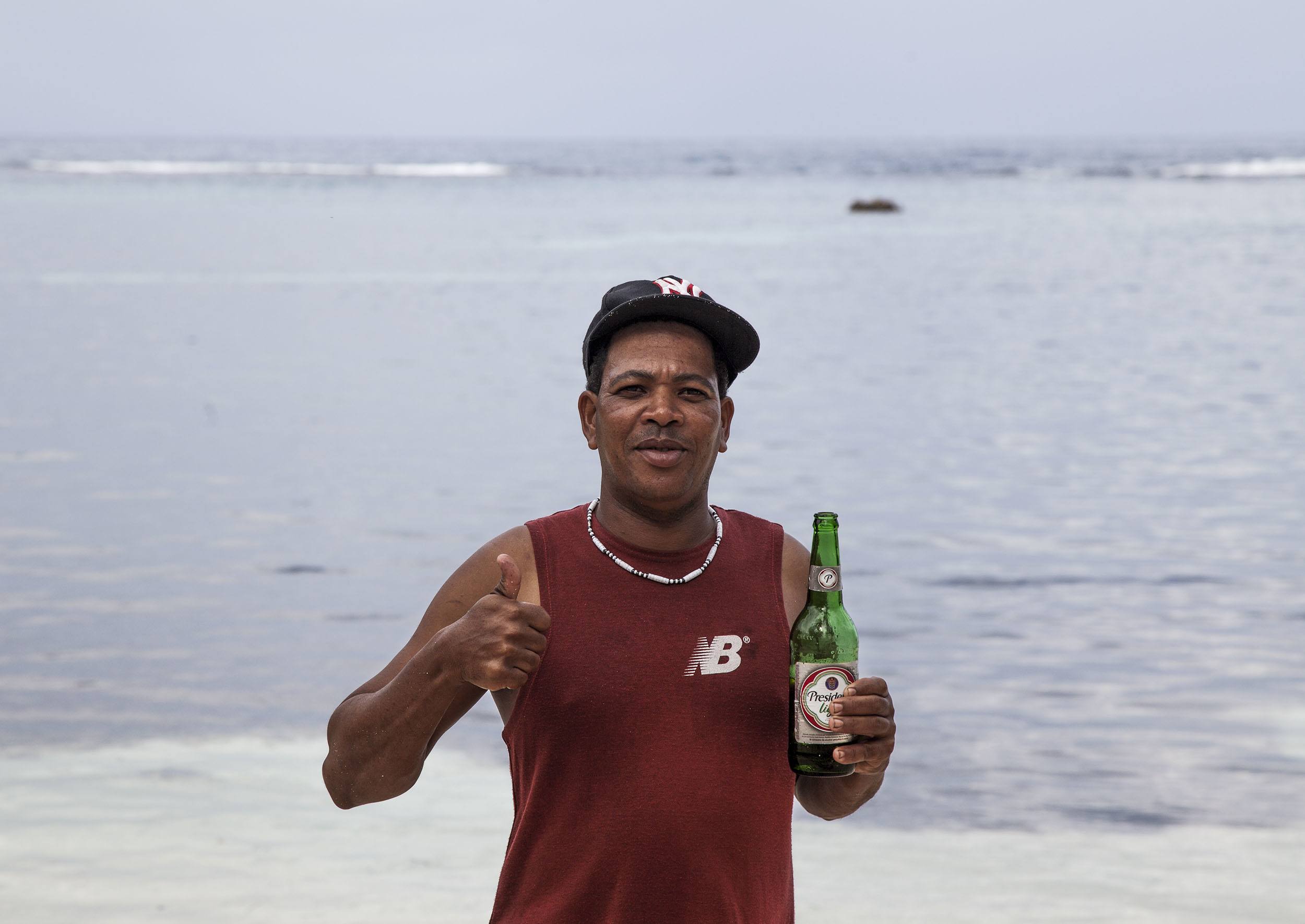 Dominican man holding beer on Playa Fronton Dominican Republic