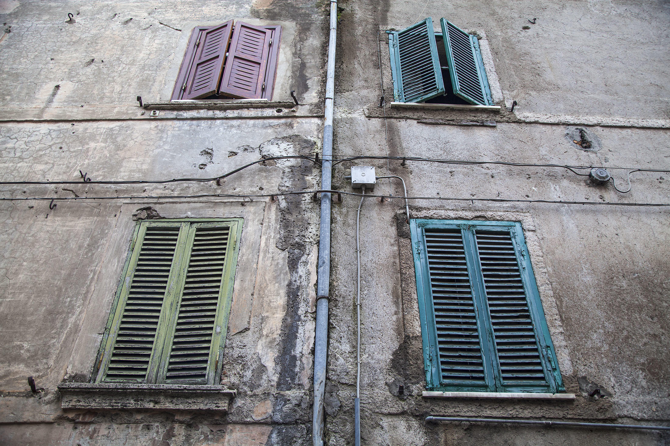 Four colourful window shutters of a house in Ferentino-Supino Italy