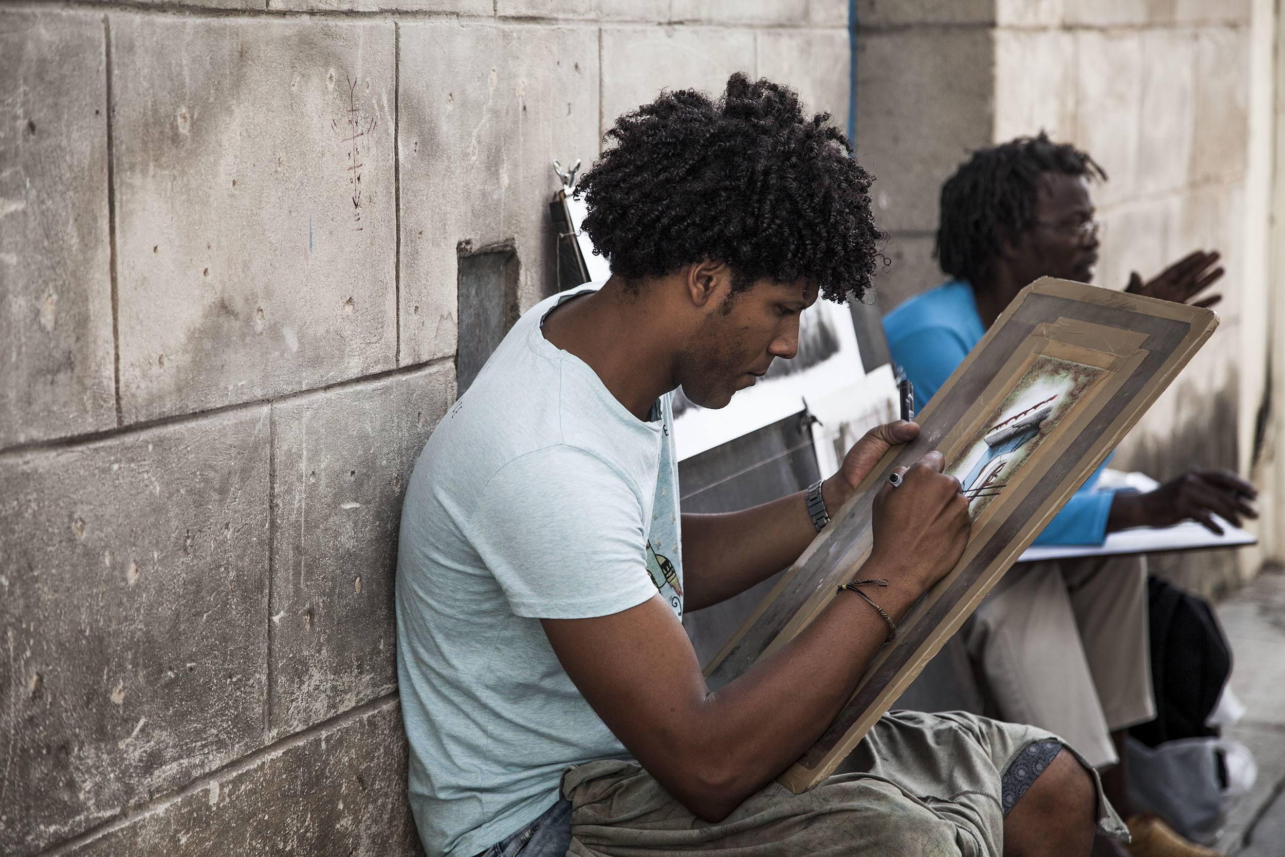 Main painting a picture in the streets of Havana Cuba