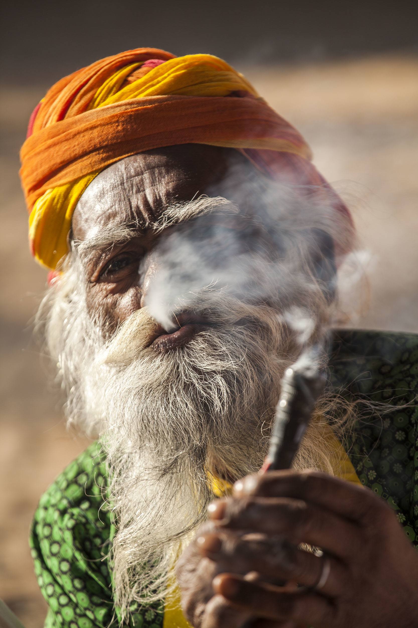 Man at village near Udaipur India smoking cigar