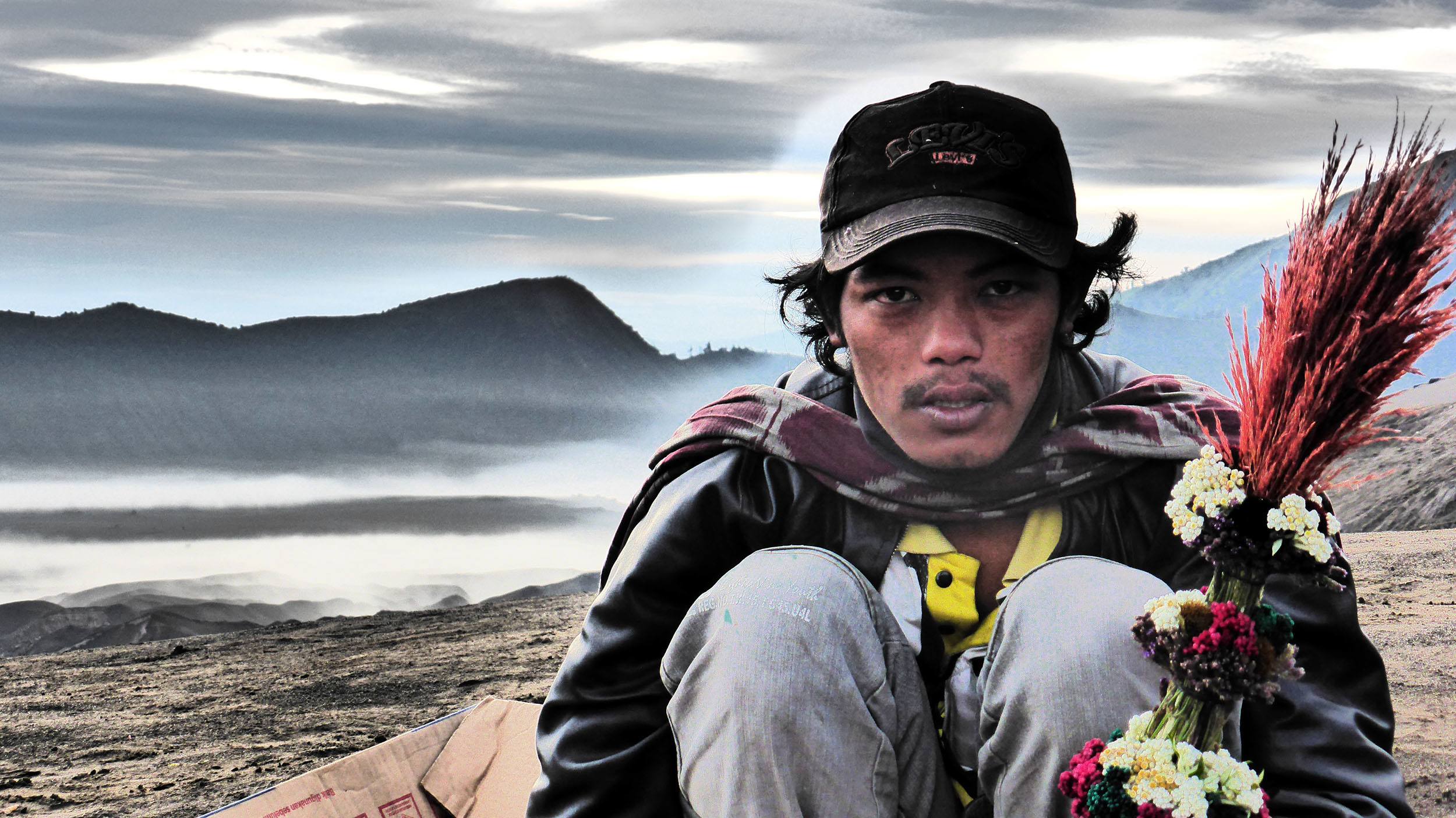 Man selling flowers in the early morning near the descent from Mount Bromo on Java Indonesia