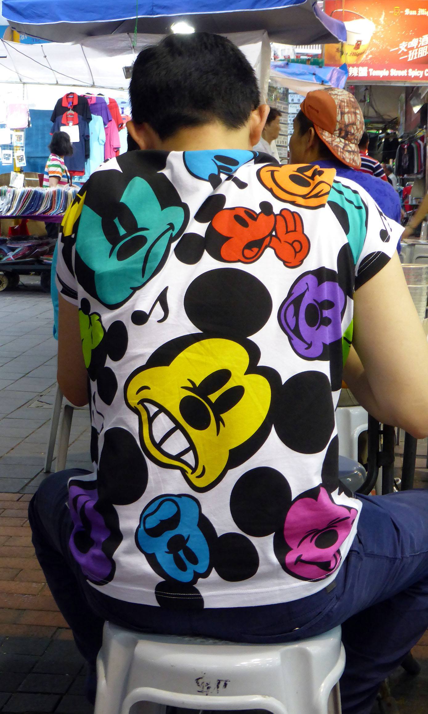 Man wearing Mickey Mouse tshirt at a food market in Hong Kong