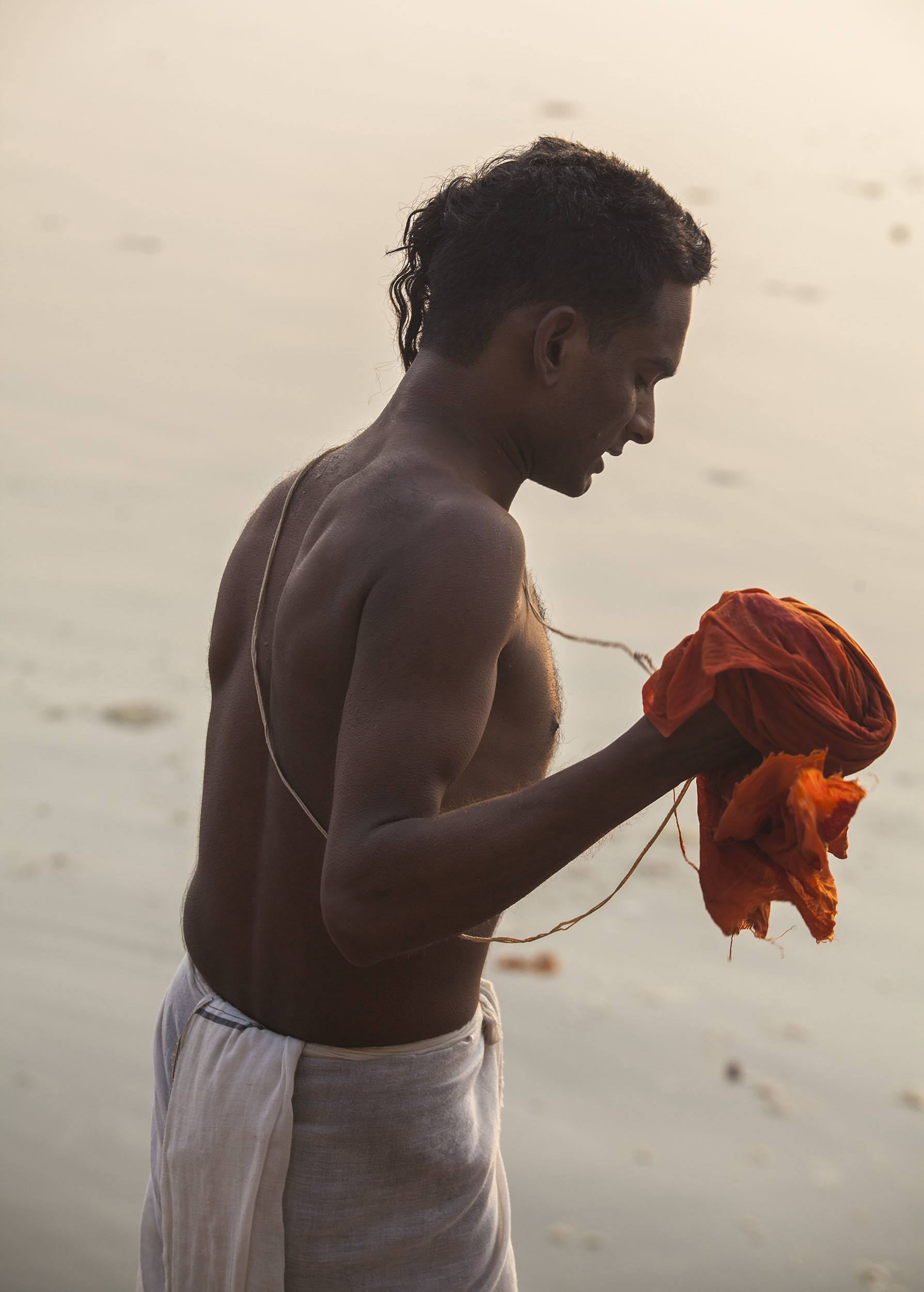 Man wearing white lungi after bathing in the Ganges in Varanasi India