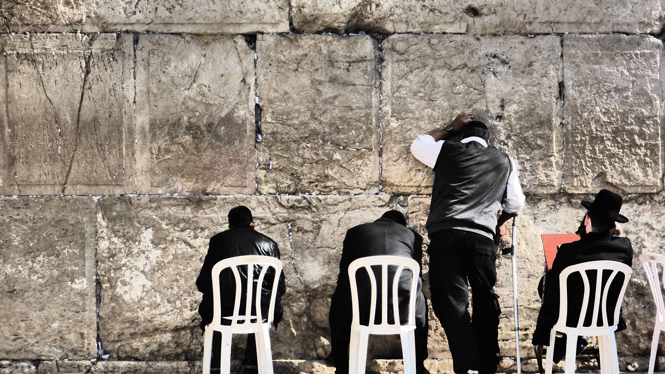 Men leaning against wailing wall in Jerusalem Israel