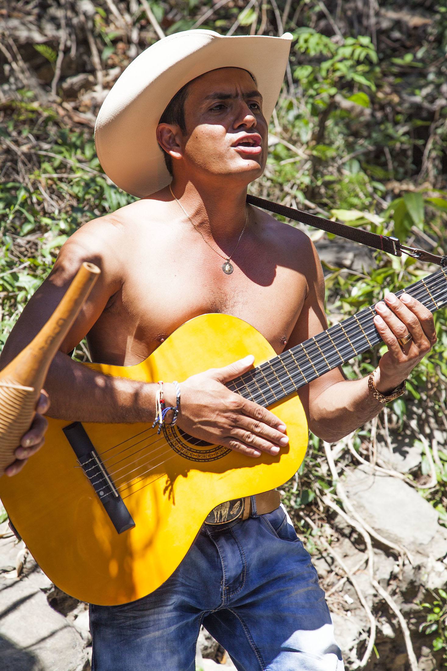 Mila playing guitar and singing beside a waterhole near Trinidad Cuba