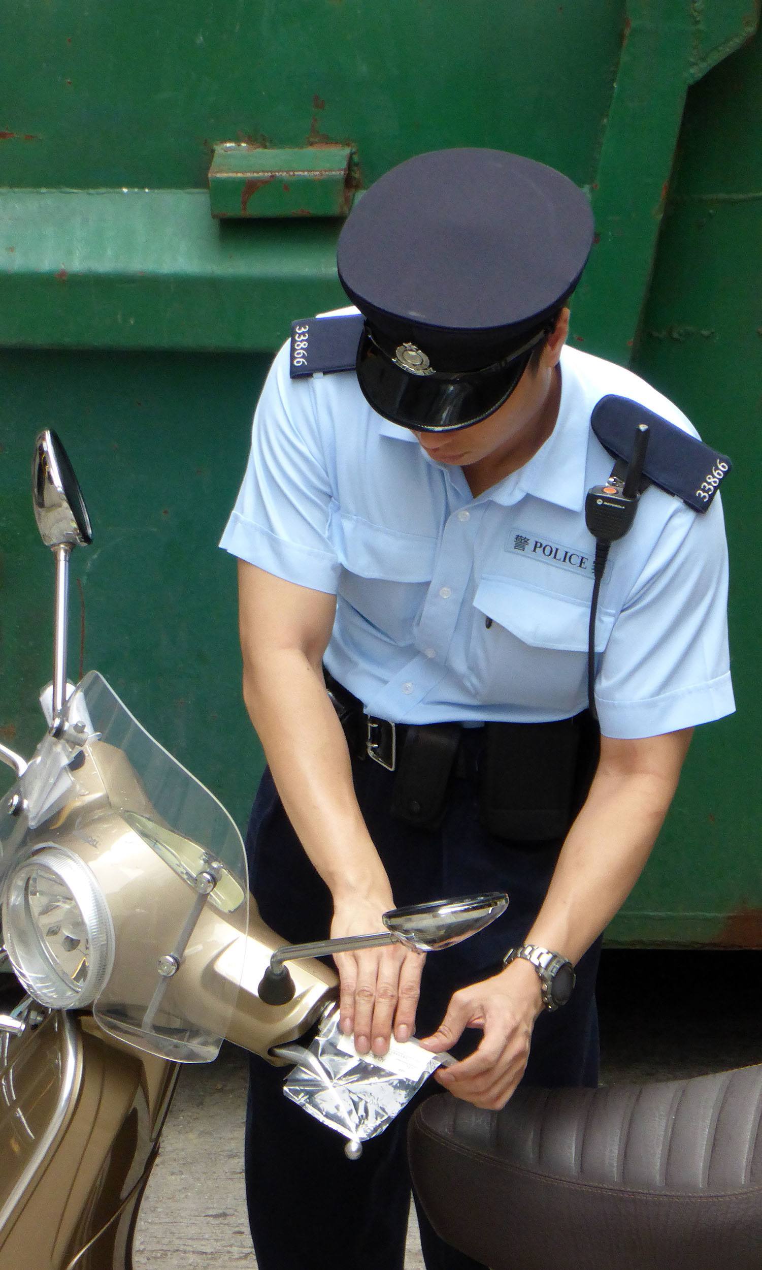 Police officer issuing a parking ticket in Hong Kong