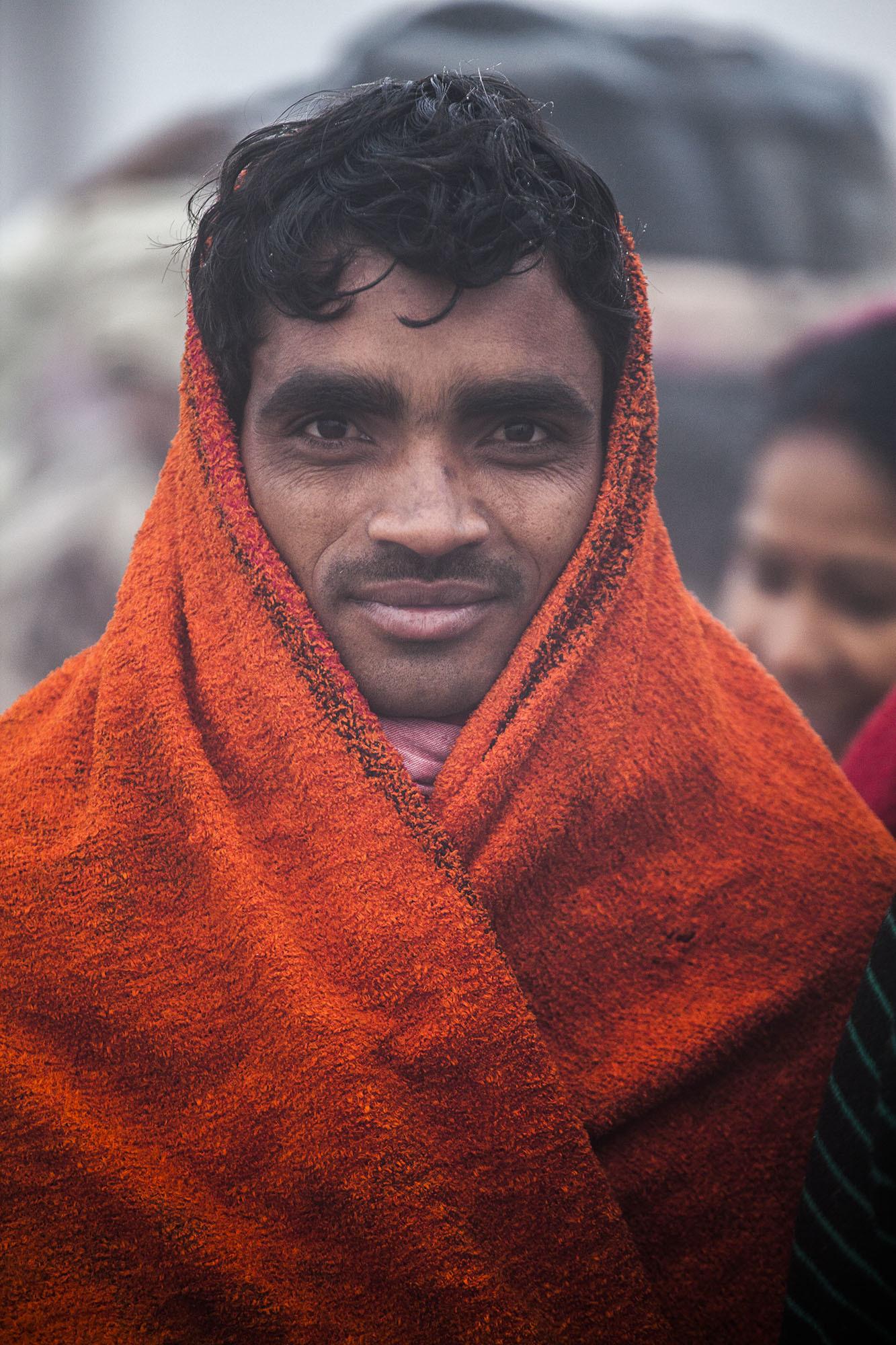 Smiling Indian man wrapped in an orange scarf at Marg Melah Allahabad India