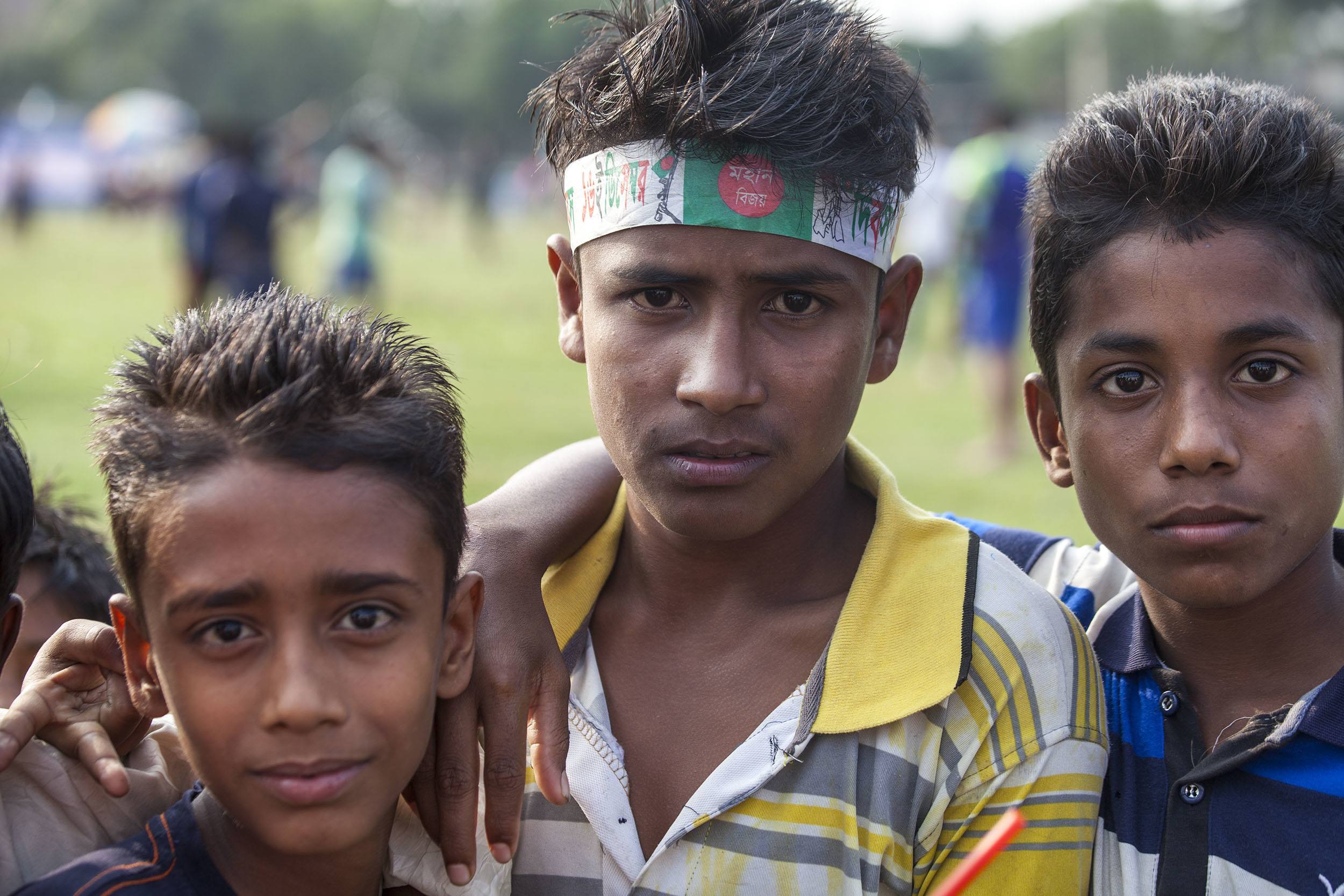 Three Bangladeshi boys posing at football game near Srimangal Bangladesh