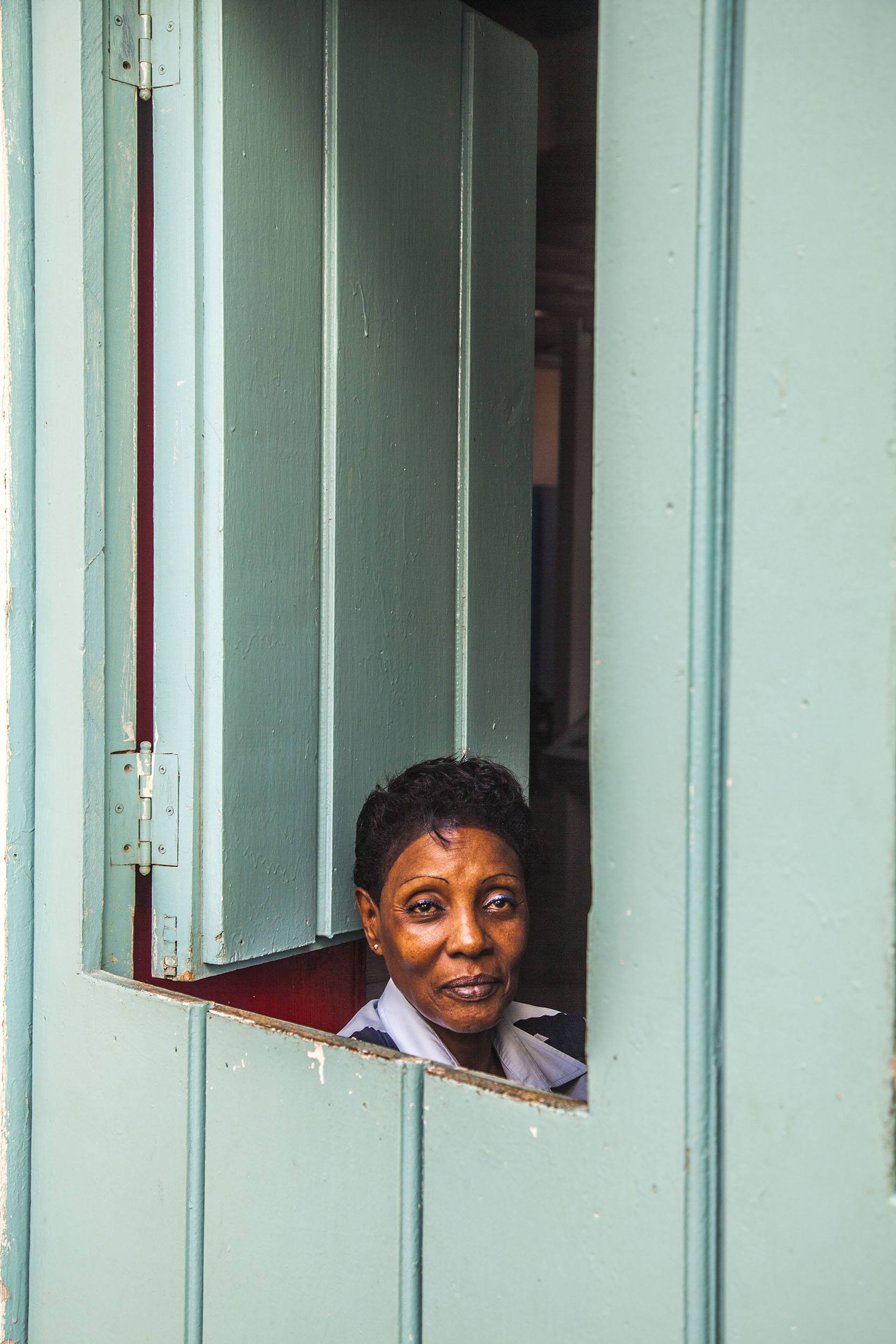 Woman framed by shop window in Havana Cuba