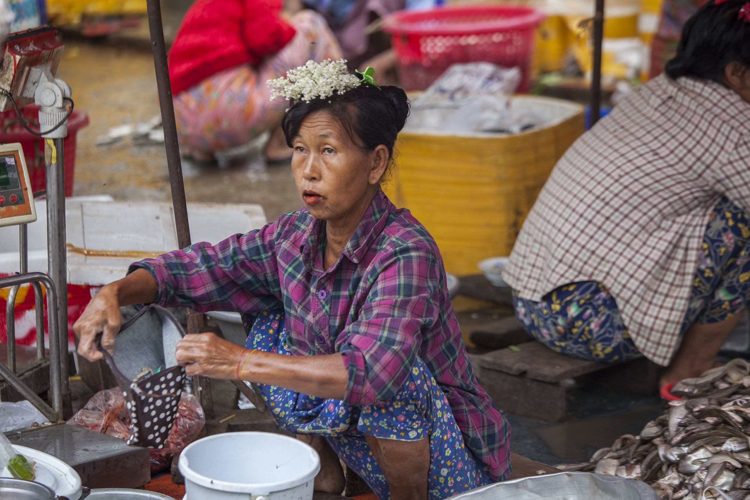 Woman wearing flowers on her head at the Fish Market in Mandalay Myanmar