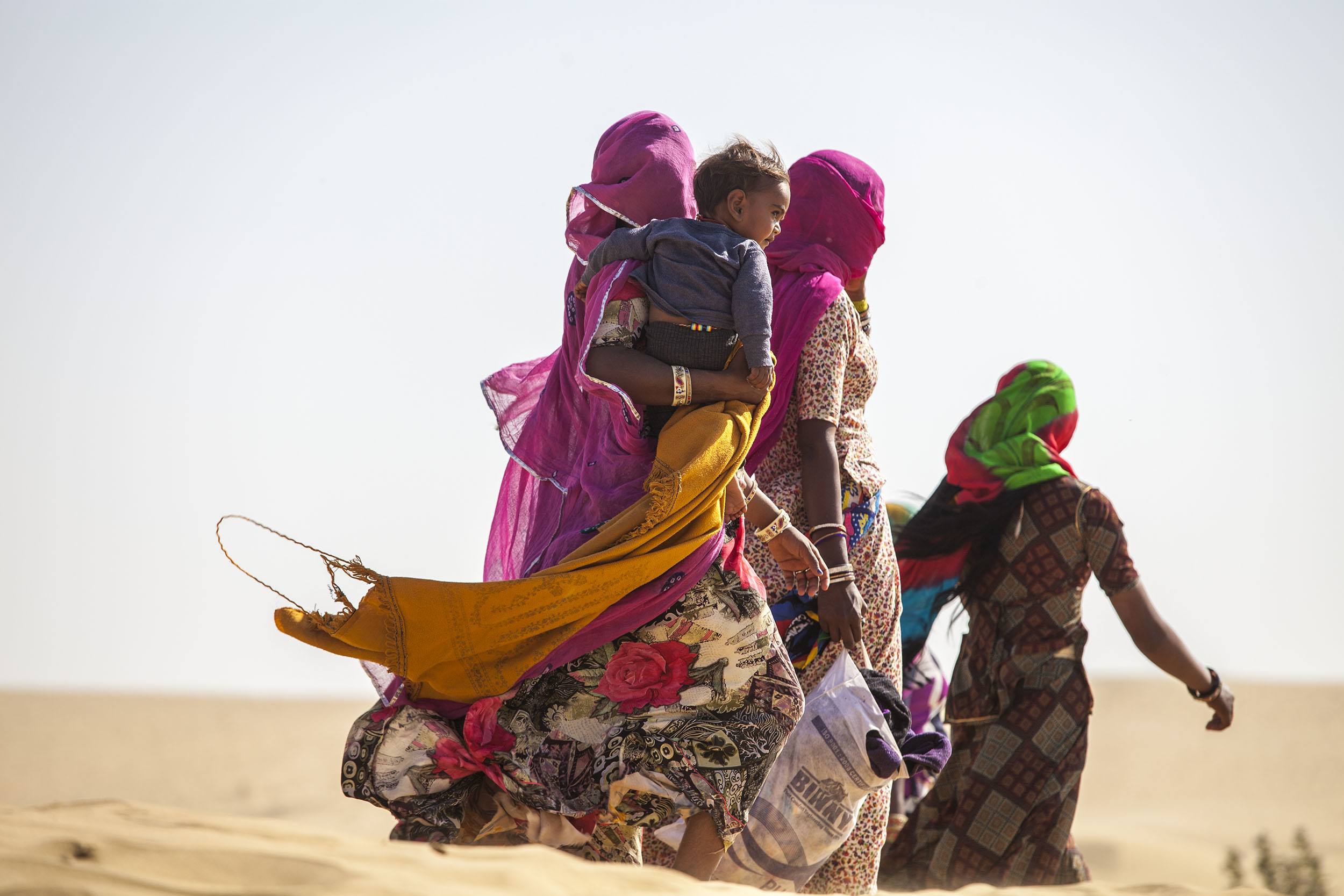 Women walking through the desert near Jaisalmer India