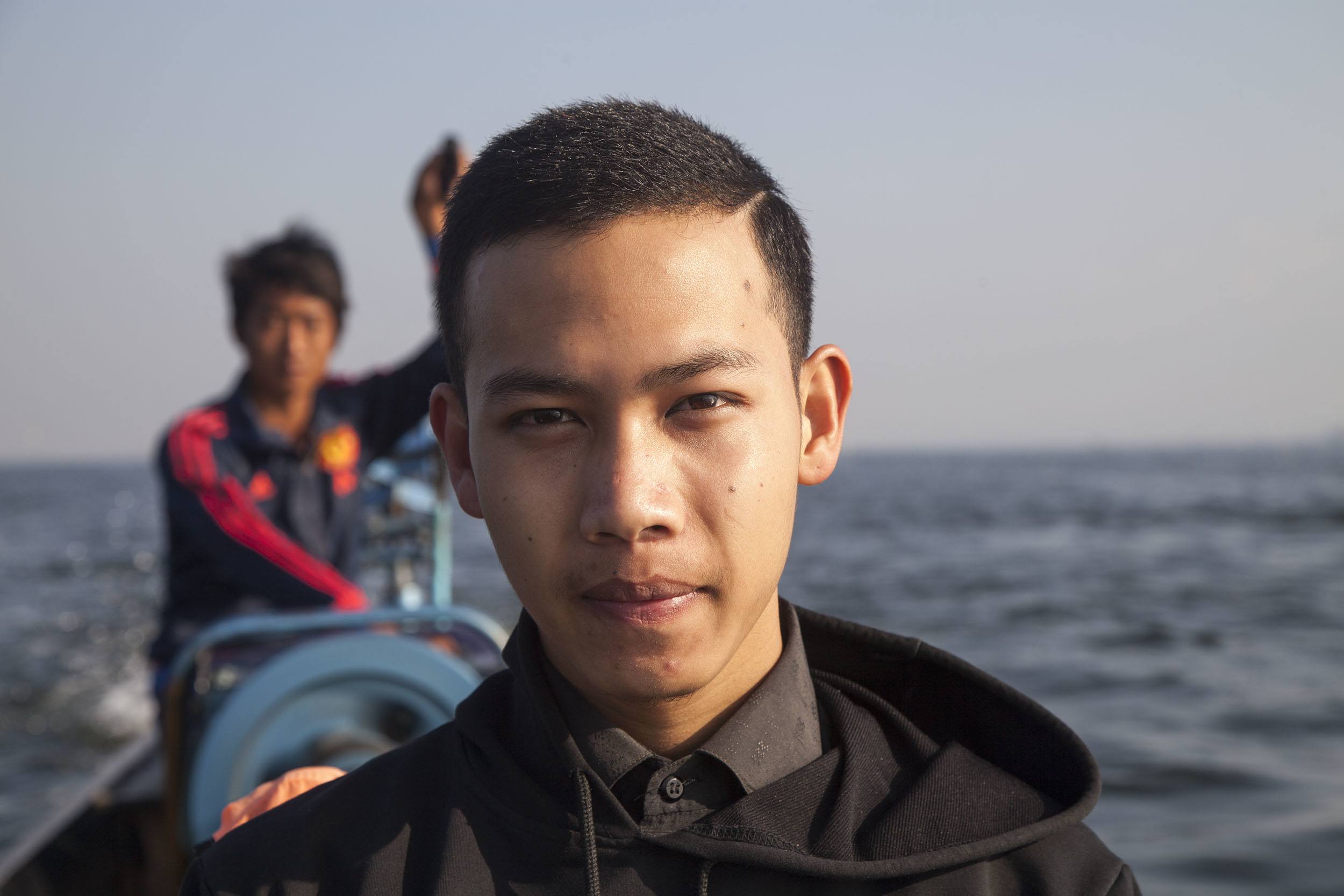 Young man on a boat crossing Inle Lake in Myanmar