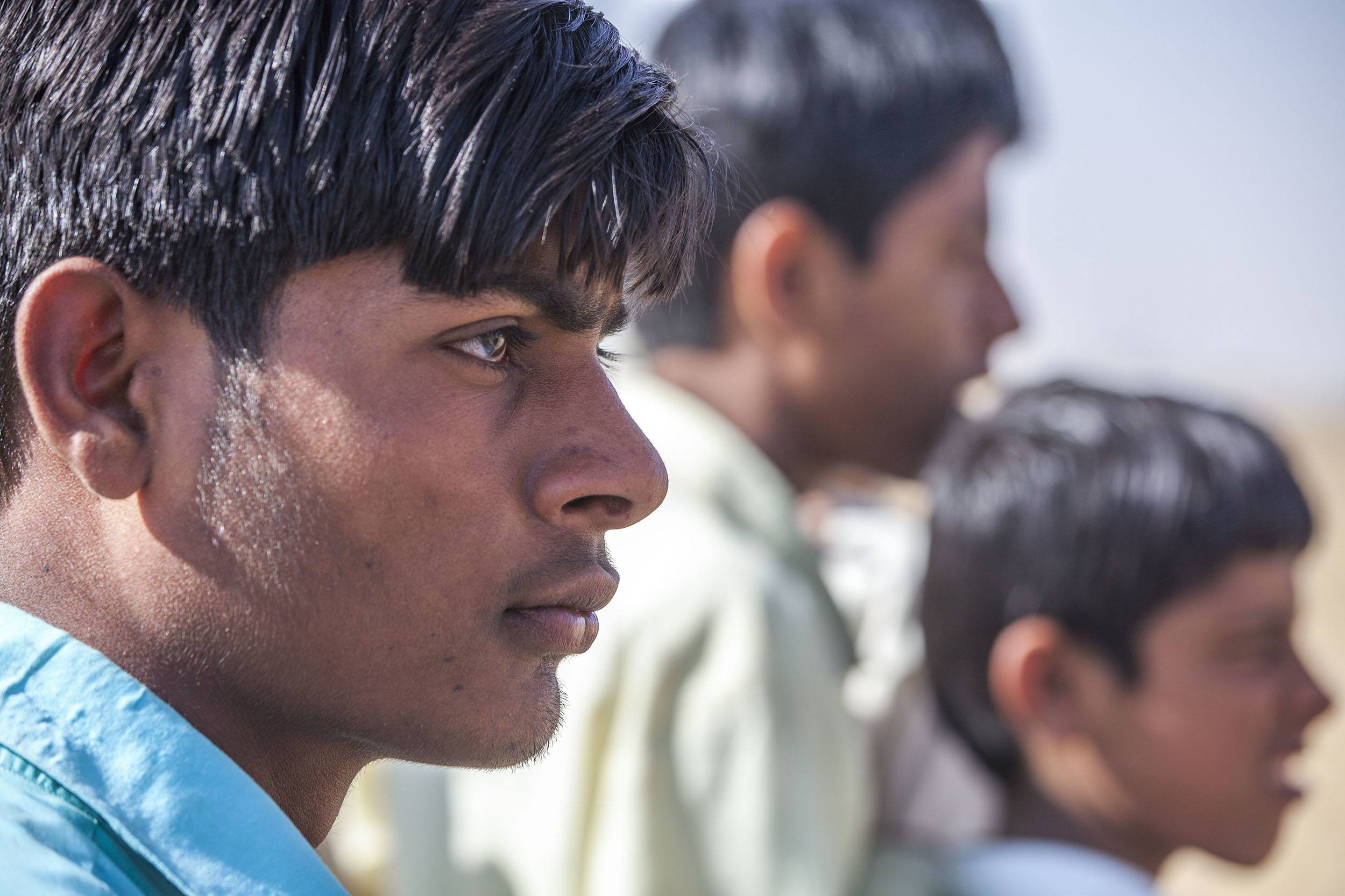 Young men watching the cames races at the Jaisalmer Desert Festival in India