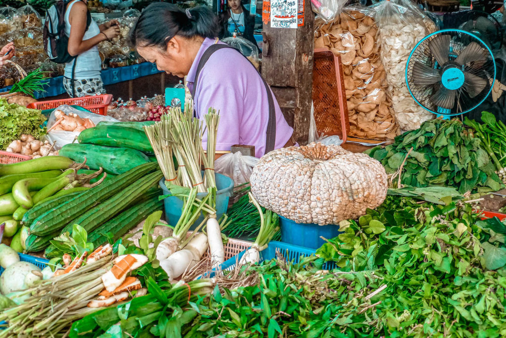 Vendor at Chiang Mai market selling fresh produce, Thailand