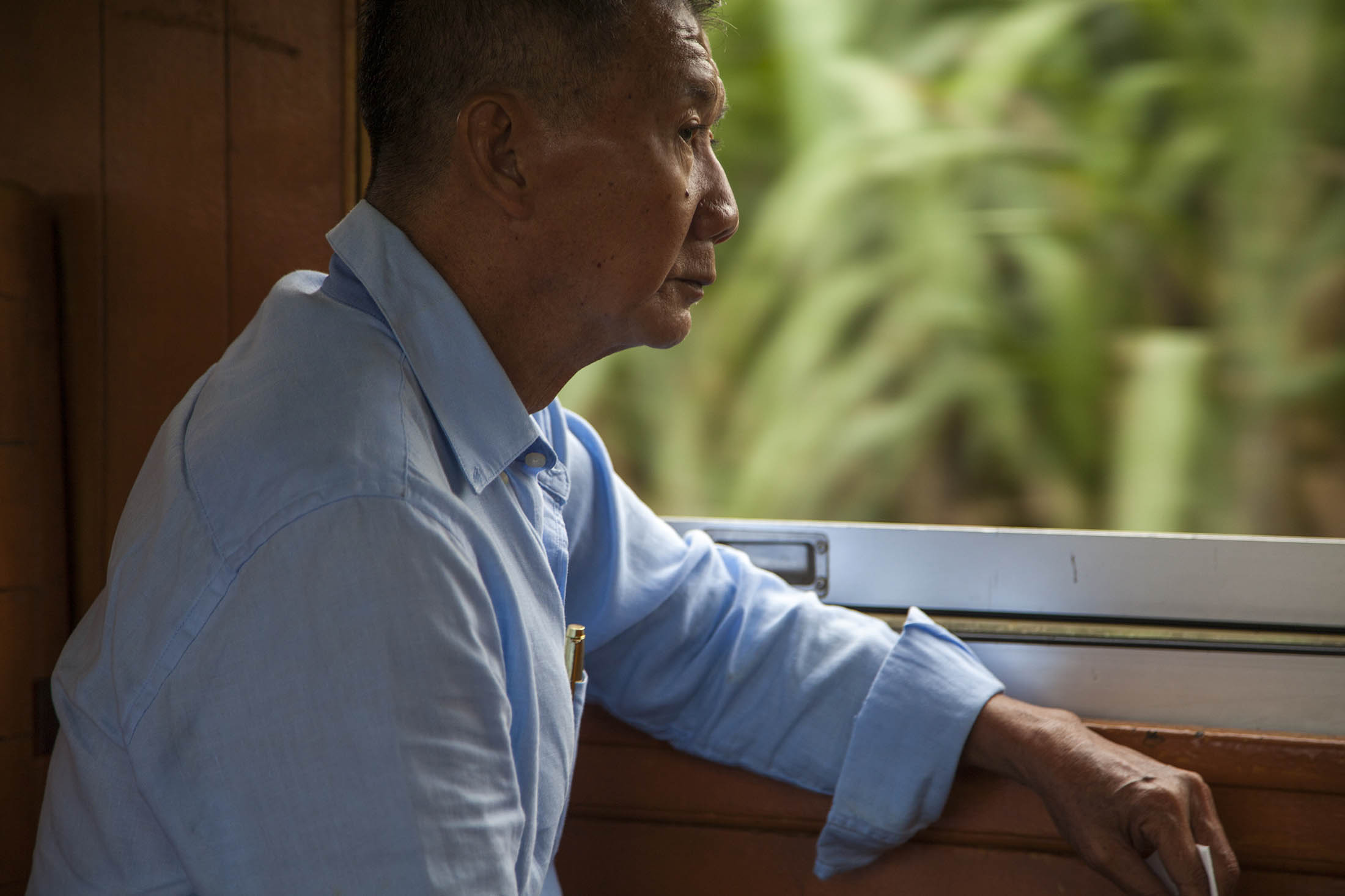 Man riding in train en route to Kanchanaburi, Thailand